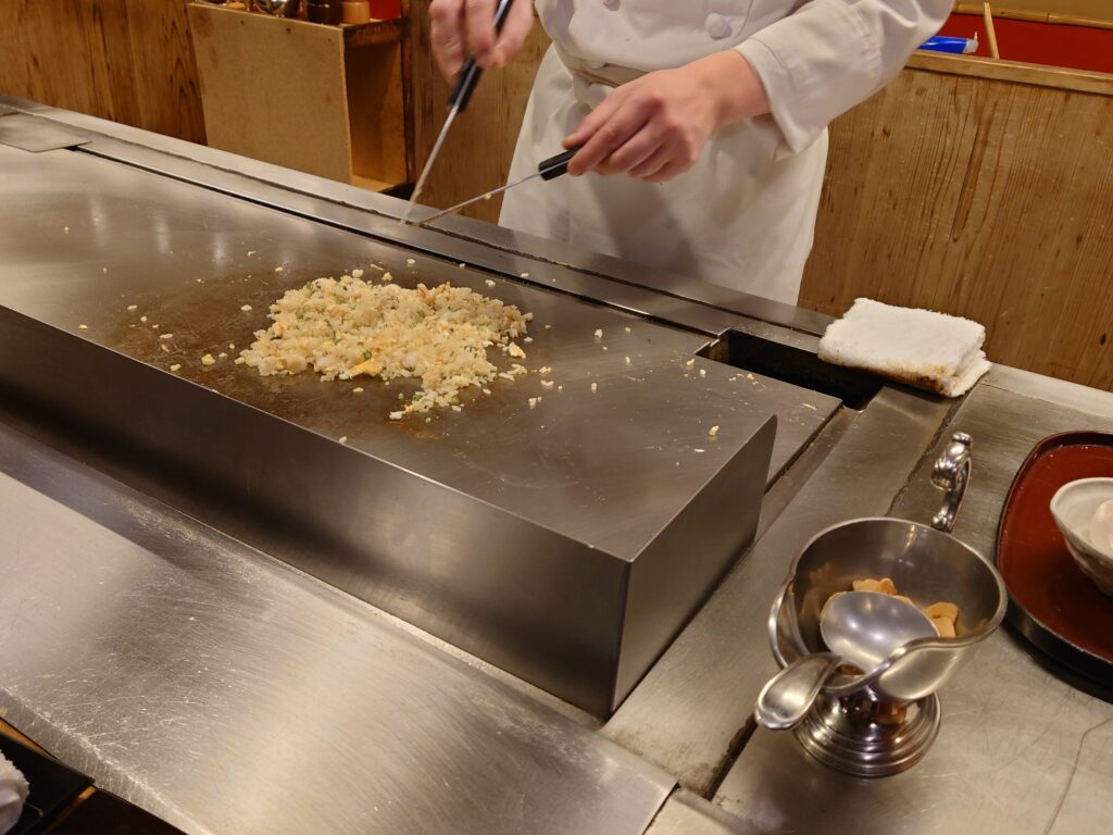 かにと肉の鉄板焼き 蟹遊亭 千葉店の鉄板でカニ焼飯を作っているところ